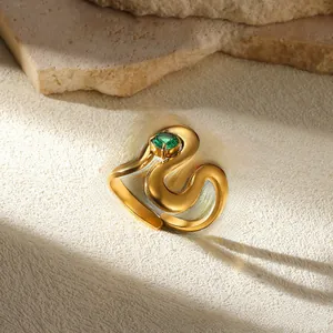 Detailed close-up of a gold snake-shaped open ring featuring a green zircon gemstone