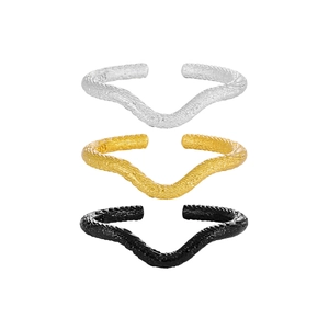 Irregular textured wave ring set in silver gold and black finishes on white background