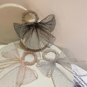 Close-up of three mesh bow hair scrunchies with sequins and crystal beads in multiple colors