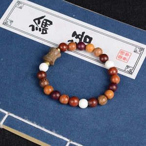 Macro detail of multi-material Buddhist prayer beads on a traditional blue book background