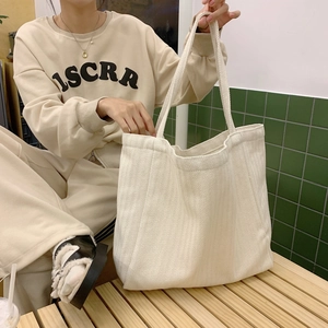 Macro detail of white canvas tote bag with herringbone knit texture and large capacity