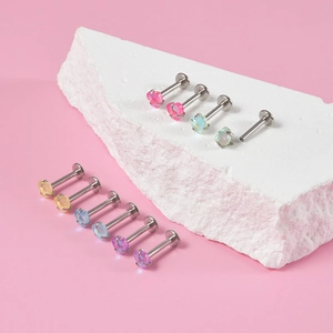 Vue macro de piercings labret en acier avec pierres colorées en forme de cœur sur pierre
