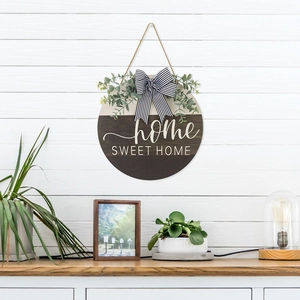 Detail of wooden HOME SWEET HOME door sign with striped bow and eucalyptus leaves