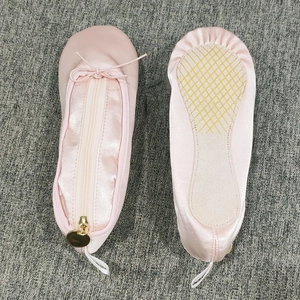 Detail view of pink satin ballet shoe pencil case with golden ring zipper and smooth texture