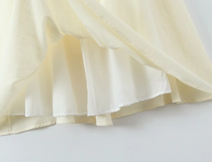 Detail des hellgelben Kleidsaums aus Baumwollleinen mit hochwertigen Nähten und Futter