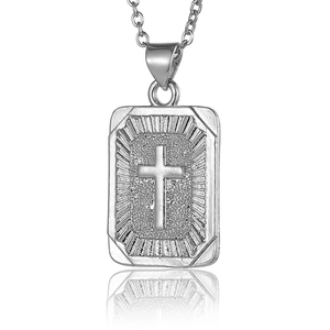 Macro shot of silver hip-hop steel square pendant with embossed cross and textured detail