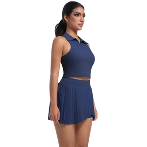 Vista laterale del set sportivo blu scuro con top senza maniche e minigonna a pieghe