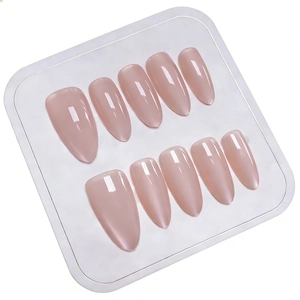 Glossy translucent pink long almond press-on nails displayed on a white professional tray
