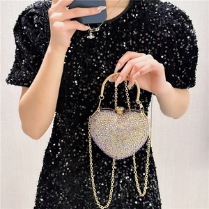 Macro view of heart-shaped evening bag with colorful rhinestones and gold metal handle