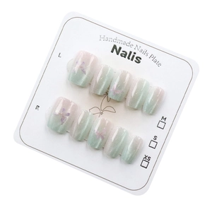 Cat eye press-on nails with mint green gradient, butterfly accents, and 10-piece set display