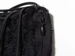 Close-up of black lace texture with invisible zipper on elegant satin dress detail