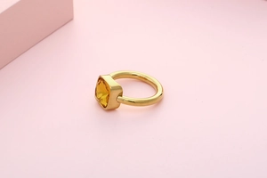 Macro top view of a gold titanium steel ring featuring a square amber zircon stone