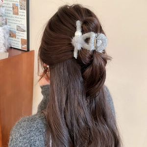 Graue Plüsch-Haarklammer mit Perlen in braunem gewelltem Haar für einen eleganten Herbstlook