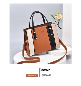 Detailed view of large color-block handbag with brown, beige, and black leather panels