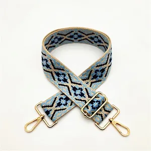 Detail of ethnic geometric woven strap in blue and black with gold metal lobster clasps