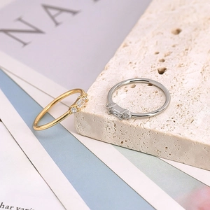 Macro detail of minimalist gold and silver rings featuring baguette-cut zircon stones