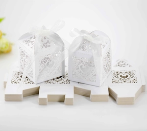Detailed laser-cut heart pattern on white pearlescent paper wedding candy box with ribbon
