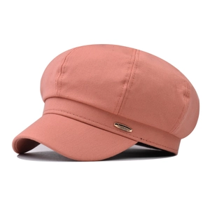 Detail of dusty pink newsboy cap showing fine wool texture and gold metal plaque
