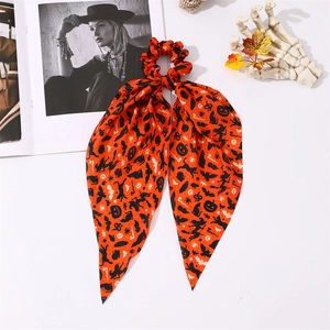 Détail d'un chouchou d'Halloween orange avec motifs citrouilles et longs rubans