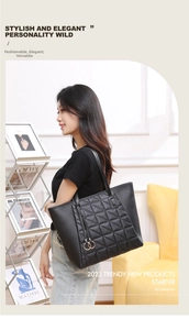 Quilted black tote bag with gold ring tassels shown in an elegant lifestyle setting