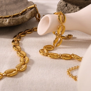 Textured 18K gold plated stainless steel coffee bean chain necklace on elegant stone tray
