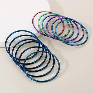 Detail shot of multi-layered 18K gold plated blue and rainbow titanium steel bangles