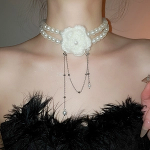 Détail d'un ras-de-cou à deux rangs de perles avec fleur au crochet et pompons argentés
