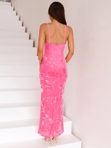 Elegante abito lungo a fiori rosa con schiena scoperta su una scala bianca moderna