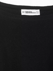 Detailed view of the black knitwear neckline with printed brand label and size information