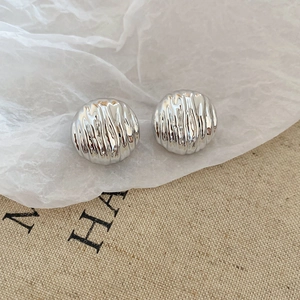 Detailed view of silver round stud earrings featuring unique water ripple texture design