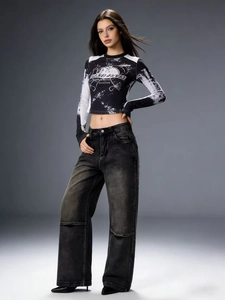 Detail der schwarzen Cargo-Jeans mit weitem Bein und bedrucktem Crop-Top im Streetstyle