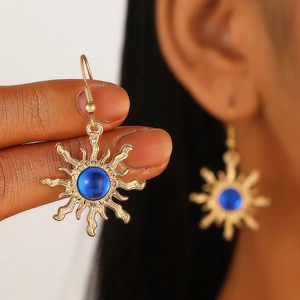 Bohemian gold sunburst earrings with blue gemstones shown on a model and in close-up