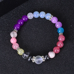 Macro shot of colorful natural stone beads and silver spacers on a black background
