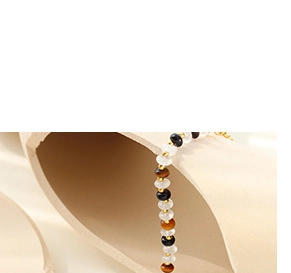 Detailed close-up of beaded bracelet with tiger eye stones and gold metal accents
