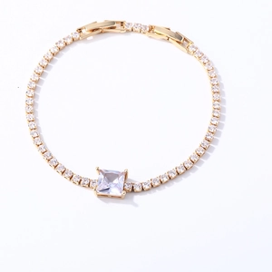 Close-up of golden tennis bracelet with square white zircon and micro-pave round stones