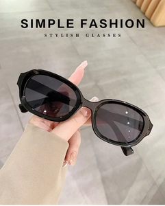 Detail of hand-held black rectangular sunglasses with premium glossy resin frames