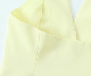Makroansicht des hellgelben Neckholder-Oberteils mit feiner Twill-Struktur und Nähten
