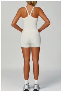 Back view of a ribbed knit yoga set featuring a white cropped tank top and high waist shorts