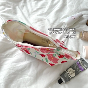 Close-up of vintage floral cosmetic bag with a unique silver circular zipper puller