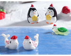 Miniature Christmas sea animals with penguins and whales in a snowy resin landscape