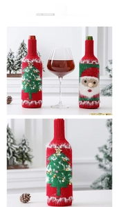 Nahaufnahme gestrickter Weinflaschenhüllen mit Weihnachtsmann- und Baum-Motiven