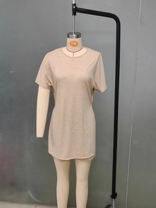 Detail view of oat beige round neck top with textured fabric and subtle curved hem