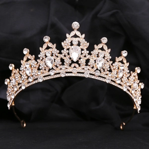 Macro shot of gold bridal tiara featuring leaf motifs with rhinestones and crystals