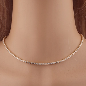 Elegant gold-plated tennis necklace with shimmering white cubic zirconia on a model