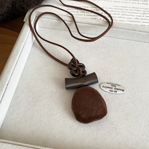 Macro detail of retro brown resin pendant necklace with textured velvet finish