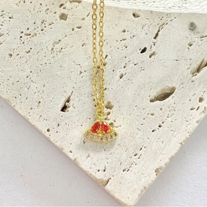 Golden necklace with watermelon slice pendant featuring red gems and white zircons
