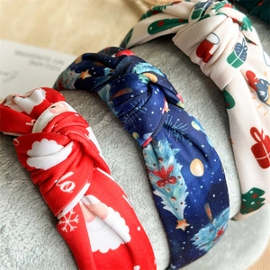 Detail of Christmas knot headbands featuring Santa and tree prints on fabric