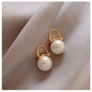 Elegant vintage style gold hook pearl earrings for women on luxury silk fabric background