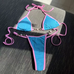 Detail of ribbed royal blue bikini with pink trim and elegant pearl bead embellishments