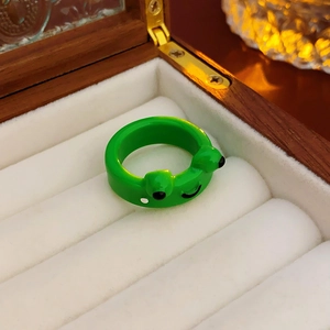 Detailed close-up of a cute green frog ring with glossy finish in a jewelry box